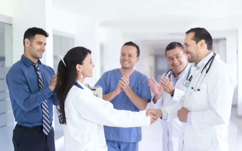 Doctors meet in the hospital corridor and shake hands